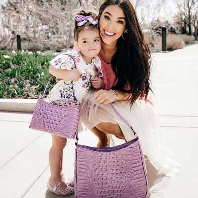 classy mom and daughter photoshoot ideas holding designer handbag 